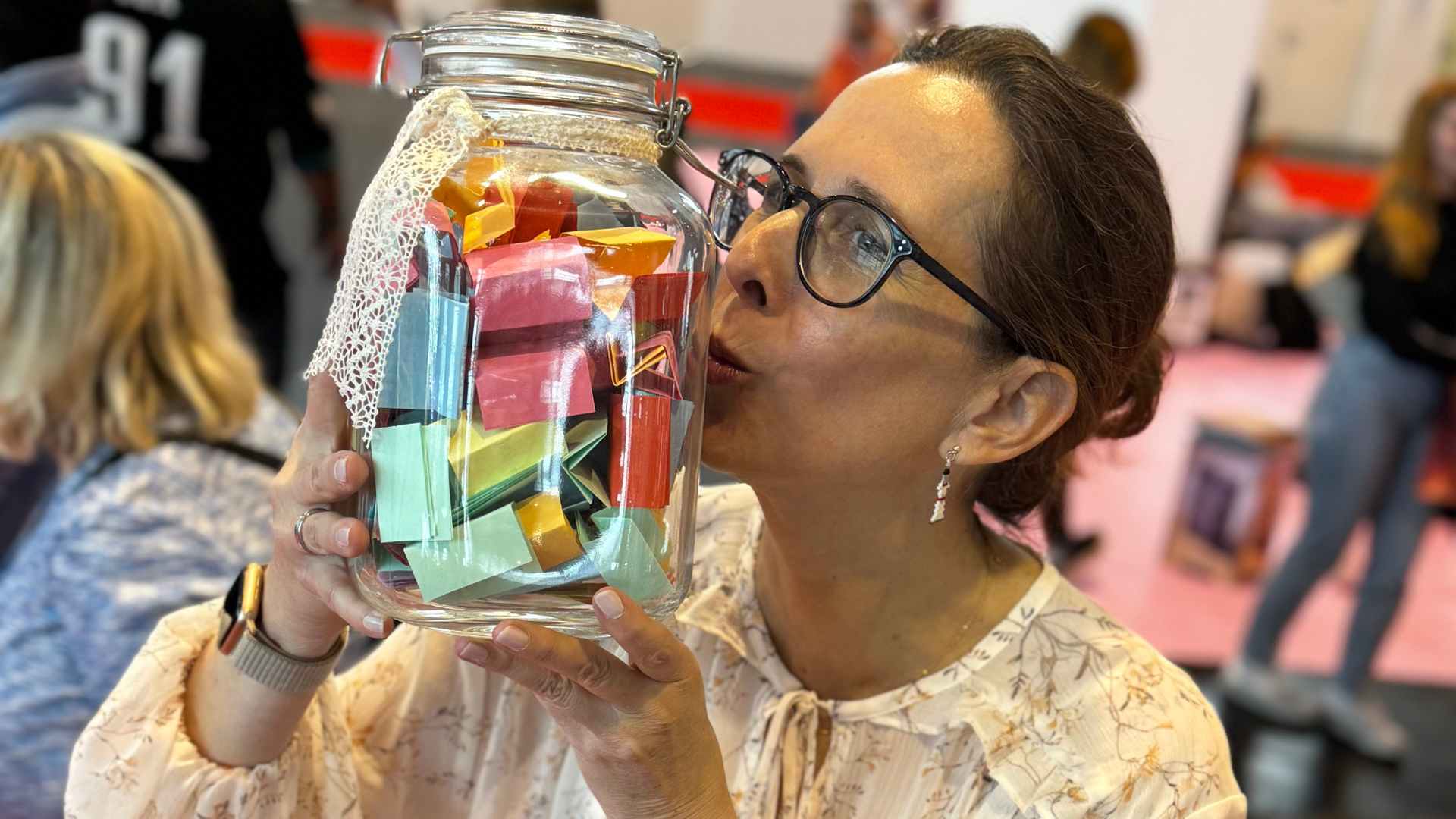 Lektorin Christine Storck hebt ein gefülltes Wünscheglas hoch und küsst es