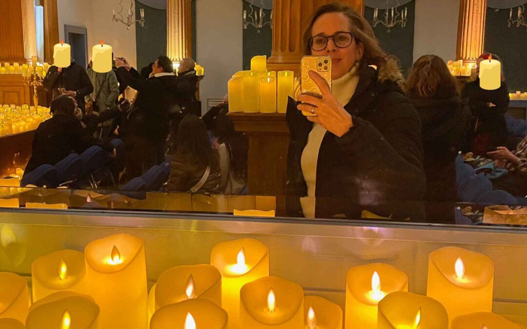 Lektorin Christine Storck steht in einem Konzertsaal inmitten von tausenden Kerzen.