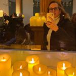 Lektorin Christine Storck steht in einem Konzertsaal inmitten von tausenden Kerzen.