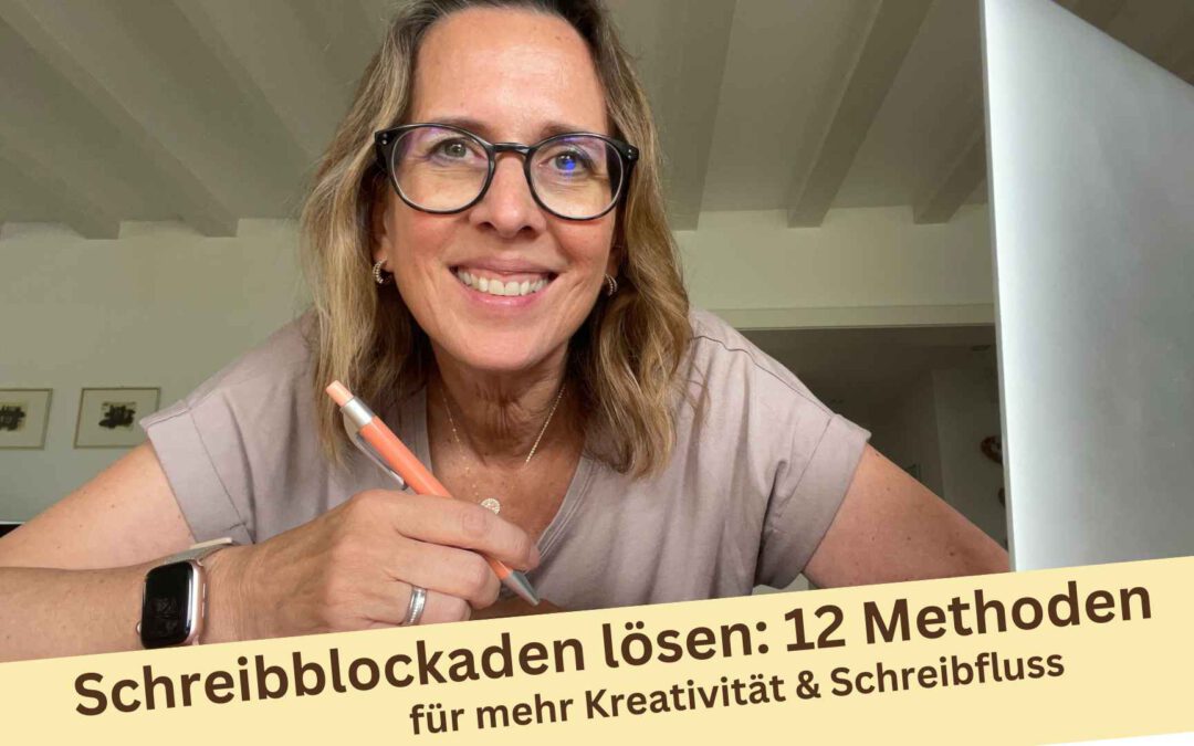 Lektorin Christine Storck sitzt mit Stift in der Hand vor ihrem Schreibtisch und lächelt in die Kamera und denkt an 12 bewährte Methoden, um Schreibblockaden aufzulösen