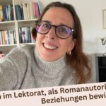 Lektorin Christine Storck steht vor ihrem Bücherregal im Wohnzimmer und lacht in die Kamera