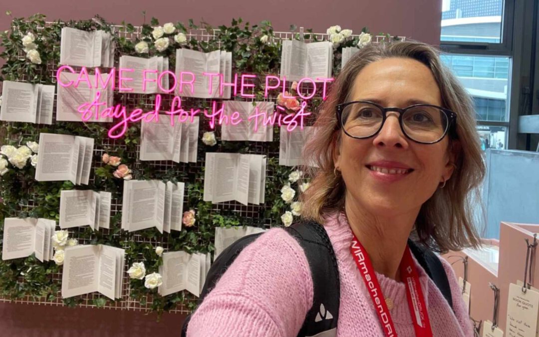 Lektorin Christine Storck steht vor einer Wand mit Büchern auf der Frankfurter Buchemsse