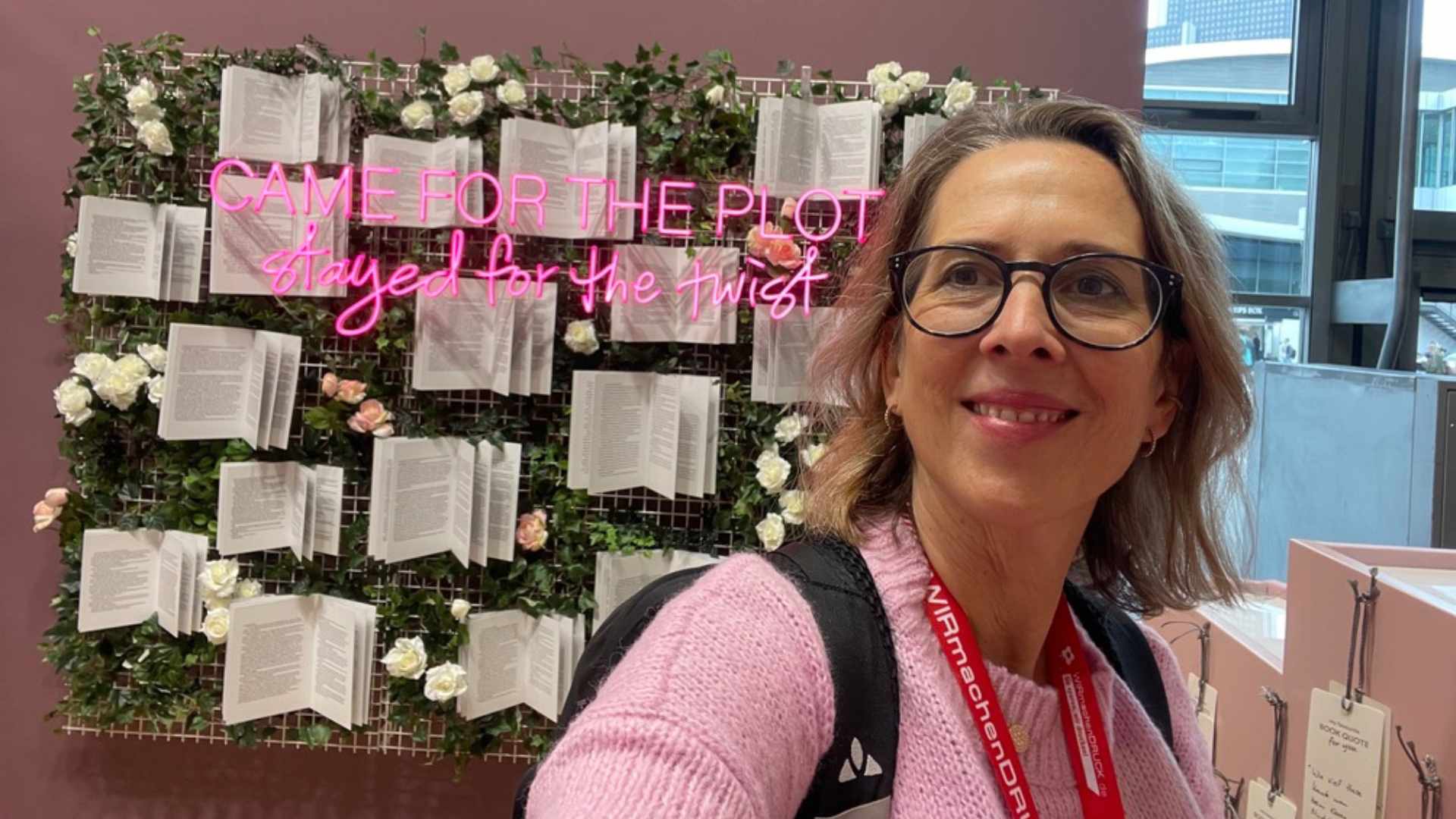 Lektorin Christine Storck steht vor einer Wand mit Büchern auf der Frankfurter Buchemsse