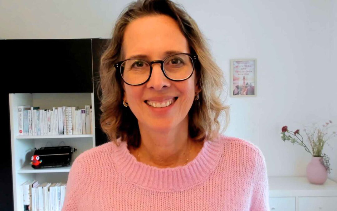 Lektorin Christine Storck steht in ihrem Büro am Schreibtisch.