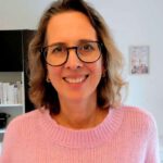 Lektorin Christine Storck steht in ihrem Büro am Schreibtisch.