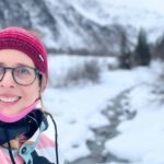 Lektorin Christine Storck lacht bei einem Schneespaziergang in Sulden/Südtirol in die Kamera.