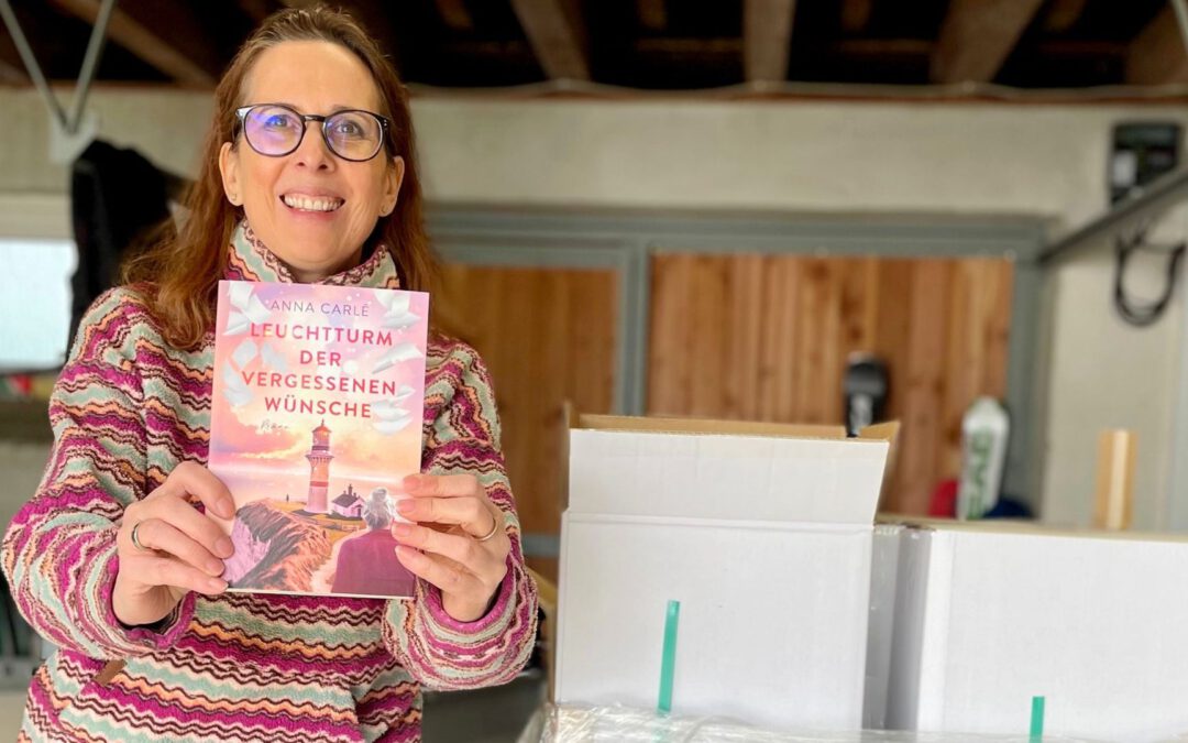 Lektorin und Romanautorin Christine Storck hält ihr frisch eingetroffenes Buch in die Kamera
