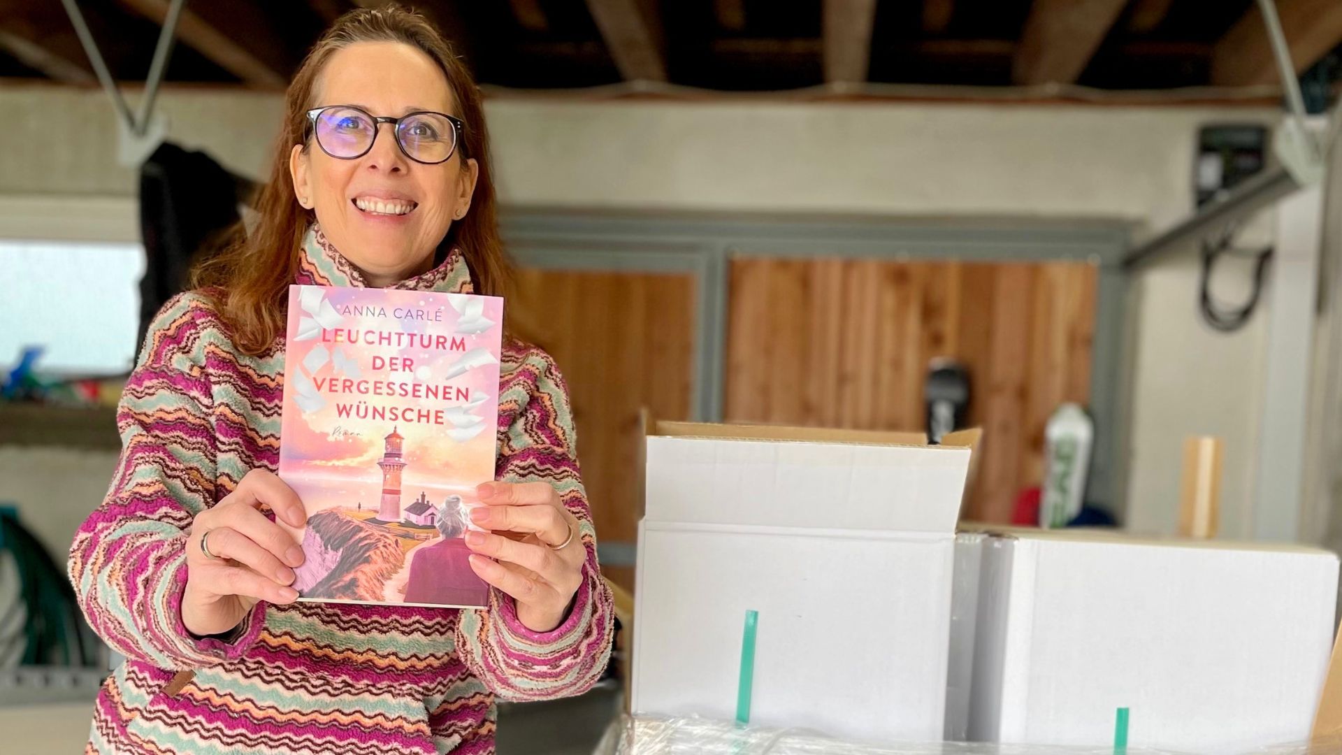 Lektorin und Romanautorin Christine Storck hält ihr frisch eingetroffenes Buch in die Kamera