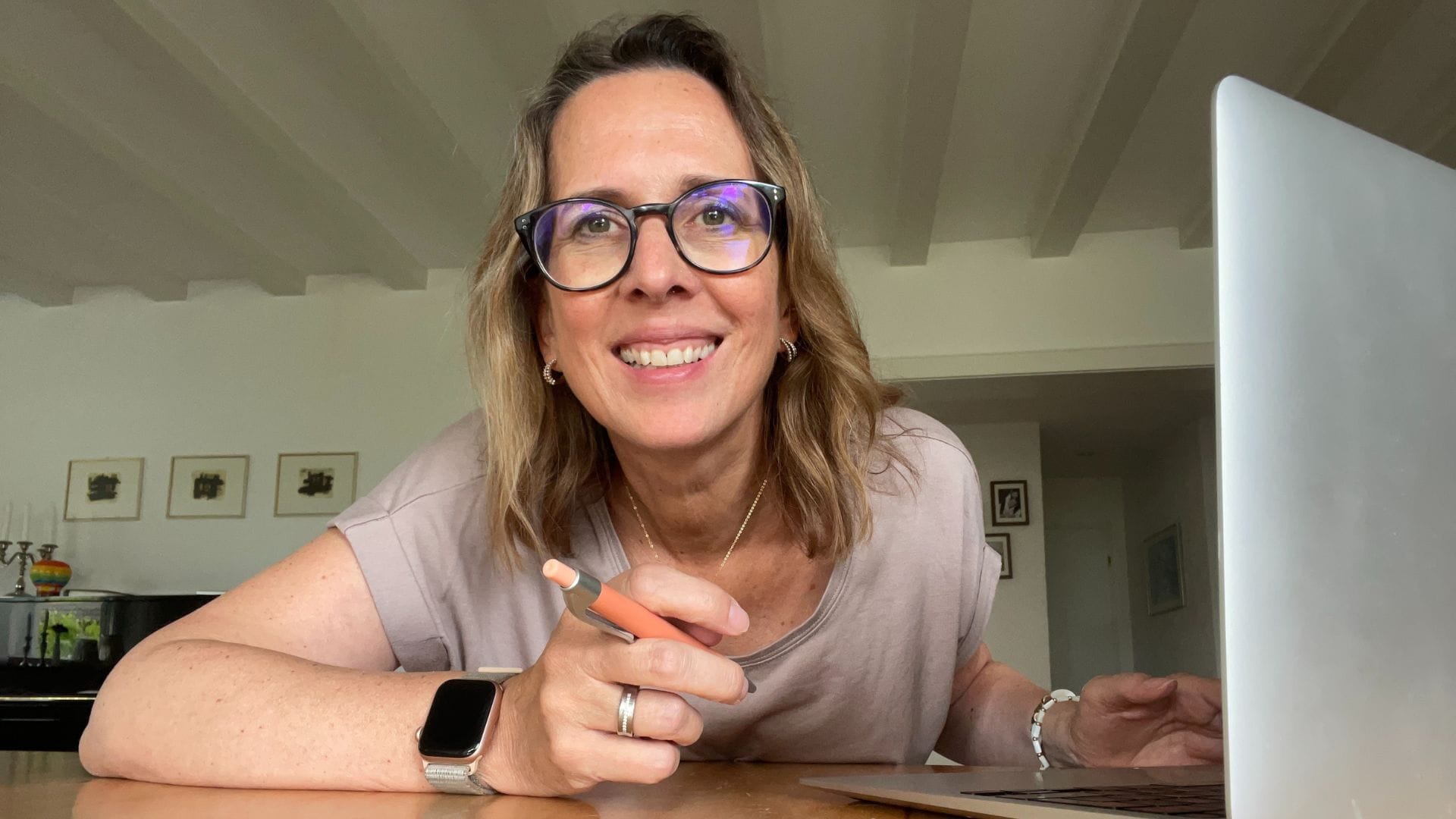 Lektorin Christine Storck sitzt an ihrem Laptop und lacht in die Kamera
